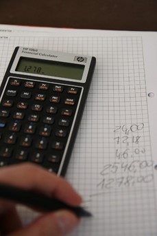 Une personne fait sa comptabilité en utilisant une calculatrice