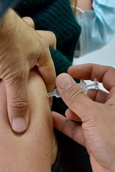 Une personne se fait vacciner dans le bras