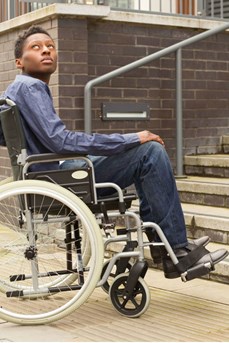 Un jeune homme en chaise roulante se retrouve bloqué devant des escaliers
