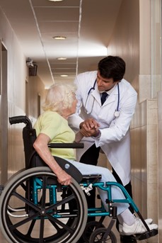 Un médecin s'occupe d'une personne âgée en fauteuil roulant dans un EHPAD