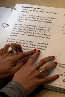 Une femme parcourt avec ses mains le plan en braille du Métro parisien