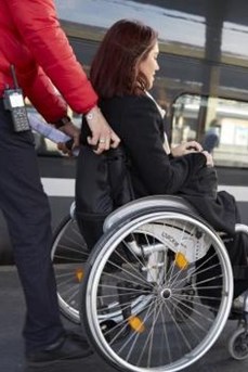 Un agent SNCF accompagne une voyageuse en fauteuil roulant jusqu'à son emplacement dans le train