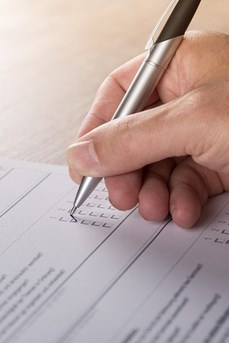 Une personne remplit le questionnaire d'une enquête avec un stylo