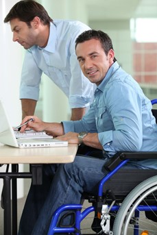 Un travailleur en fauteuil roulant est en pleine réunion de travail