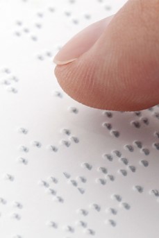 Une personne aveugle lit un texte en braille avec son doigt