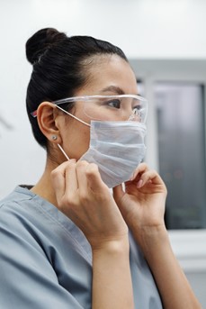 Une infirmière positionne son masque chirurgical sur le visage