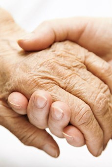 En signe d'entraide, une main soutient celle d'une personne âgée dépendante