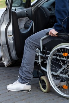 Un homme en fauteuil roulant s'apprête à rentrer dans sa voiture