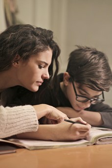 Une maman aide son fils avec ses devoirs scolaires