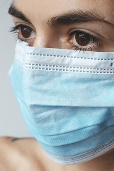 Une femme porte sur le visage un masque de protection contre le virus