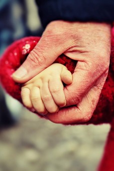 Un papa tient la petite main de sa fille dans la rue