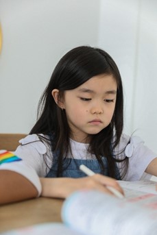 Une jeune élève est concentrée sur son travail à l'école