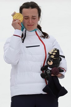 Marie Bochet, émue sur le podium, tient à la main la médaille d'or pour sa victoire dans le slalom