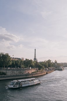 Vue de Paris avec au premier plan un bateau-mouche sur la Seine et au fond la Tour Eiffel