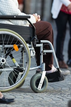 Une femme en fauteuil roulant au milieu des gens dans une rue
