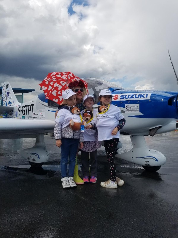Trois petites filles et un clown devant un avion lors de l'opération Rêves de Gosse 2022
