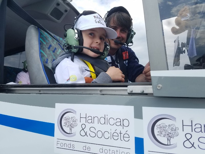 Un enfant dans le cockpit de l'avion pour l'opération Rêves de Gosse
