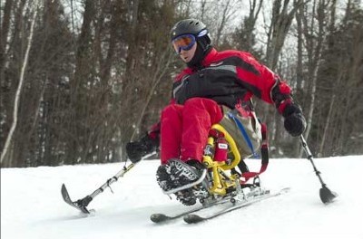 Un skieur handicapé utilisant un dualski et des stabilos