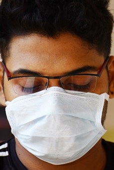 Un jeune homme porte un masque chirurgical blanc pour le protéger du coronavirus