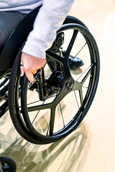 Une personne à mobilité réduite utilise le système Dreeft installé sur les roues de son fauteuil roulant