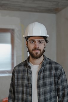Un jeune travailleur en bâtiment avec un casque de chantier blanc