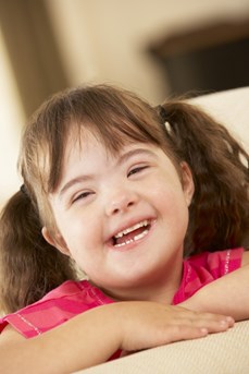 Une enfant atteinte de trisomie 21 sourit