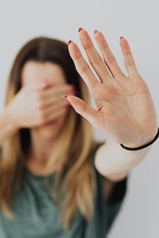 Une femme dit stop aux violences en tendant sa main devant elle