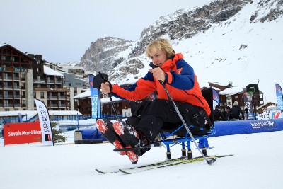 Une femme pratique le ski de fond grâce à une luge nordique